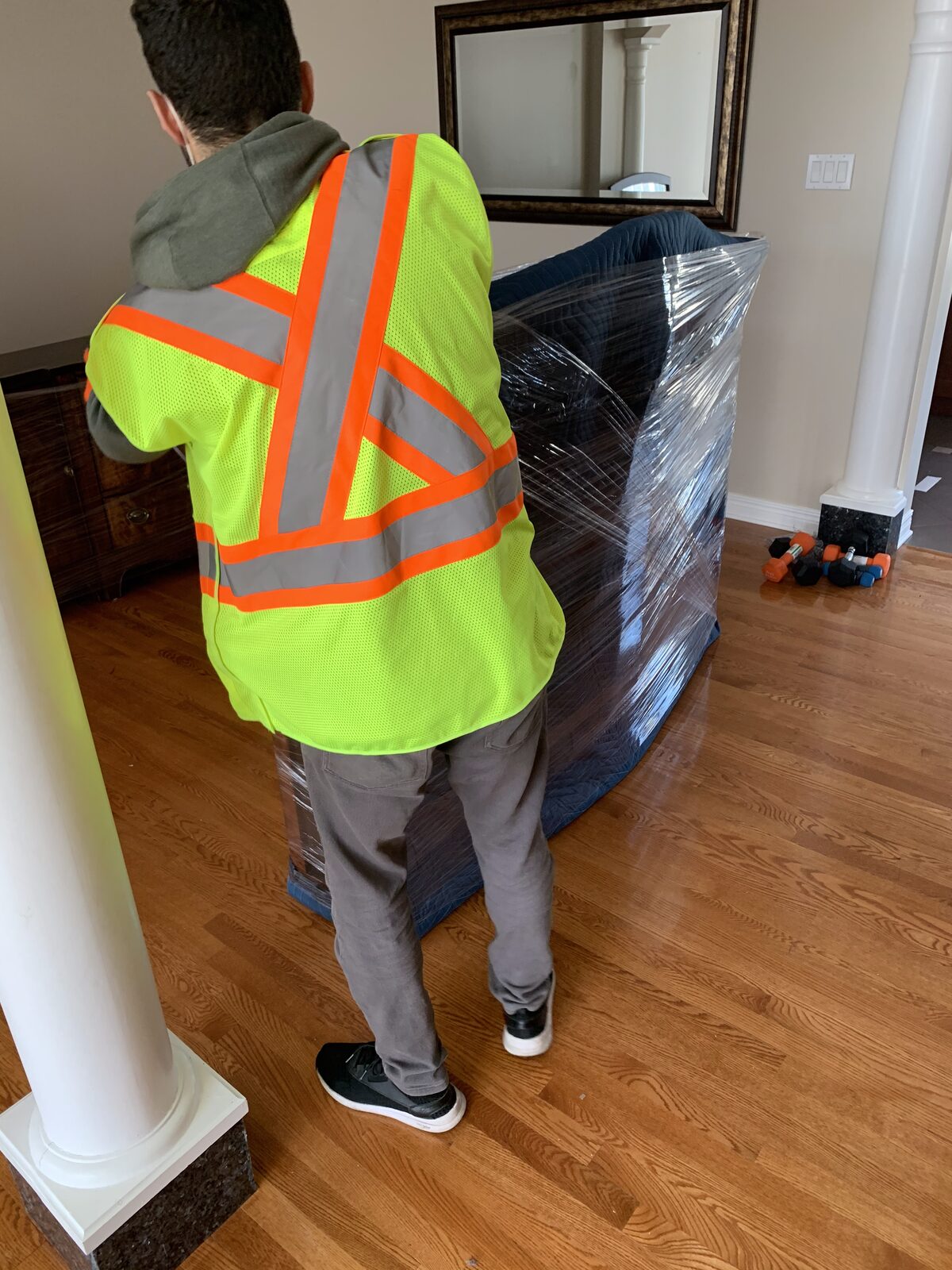 Men In Trucks mover carrying wrapped furniture through an Ottawa home
