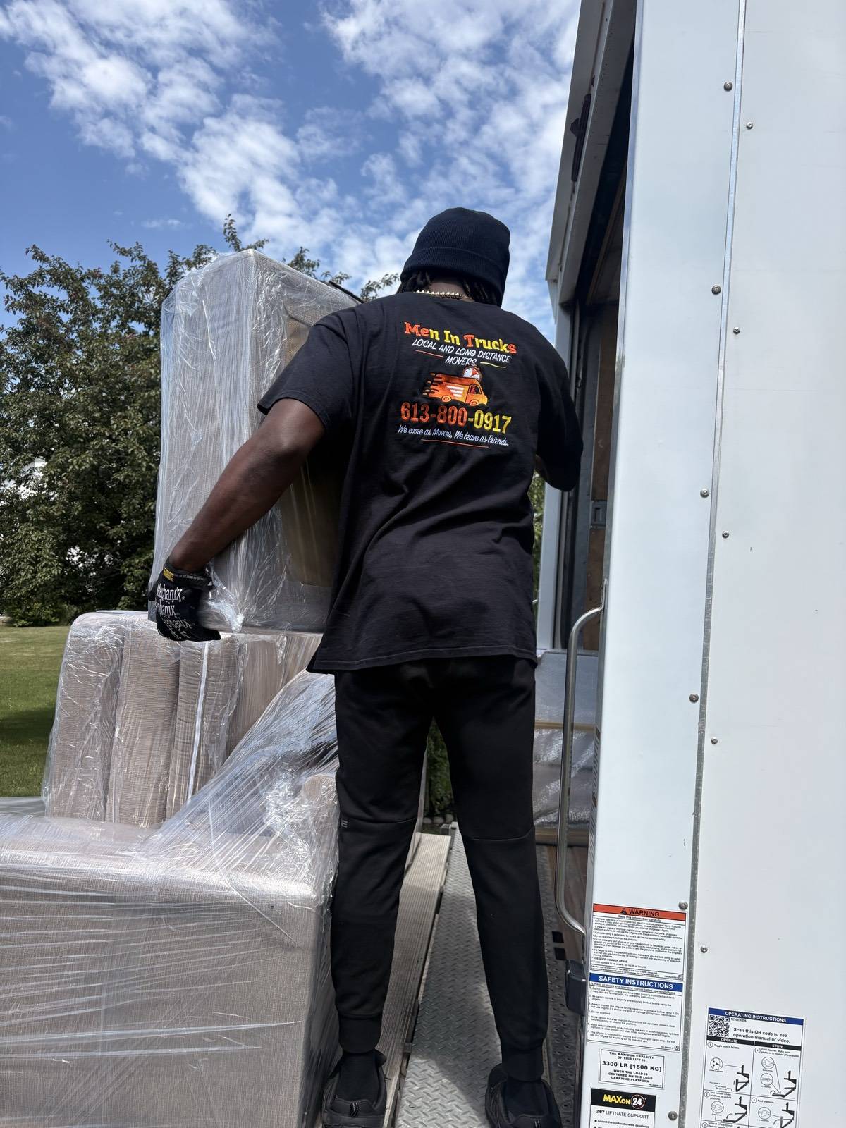 Men In Trucks mover loading a shrink-wrapped mattress on the truck liftgate in Ottawa