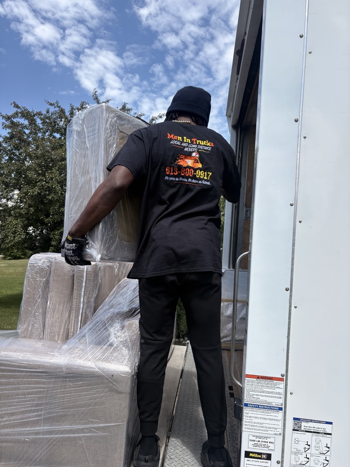 Men In Trucks mover loading wrapped furniture onto the truck liftgate in Ottawa