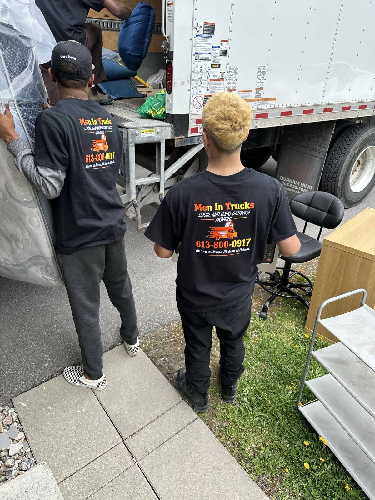 Men In Trucks crew loading a moving truck outside a family home