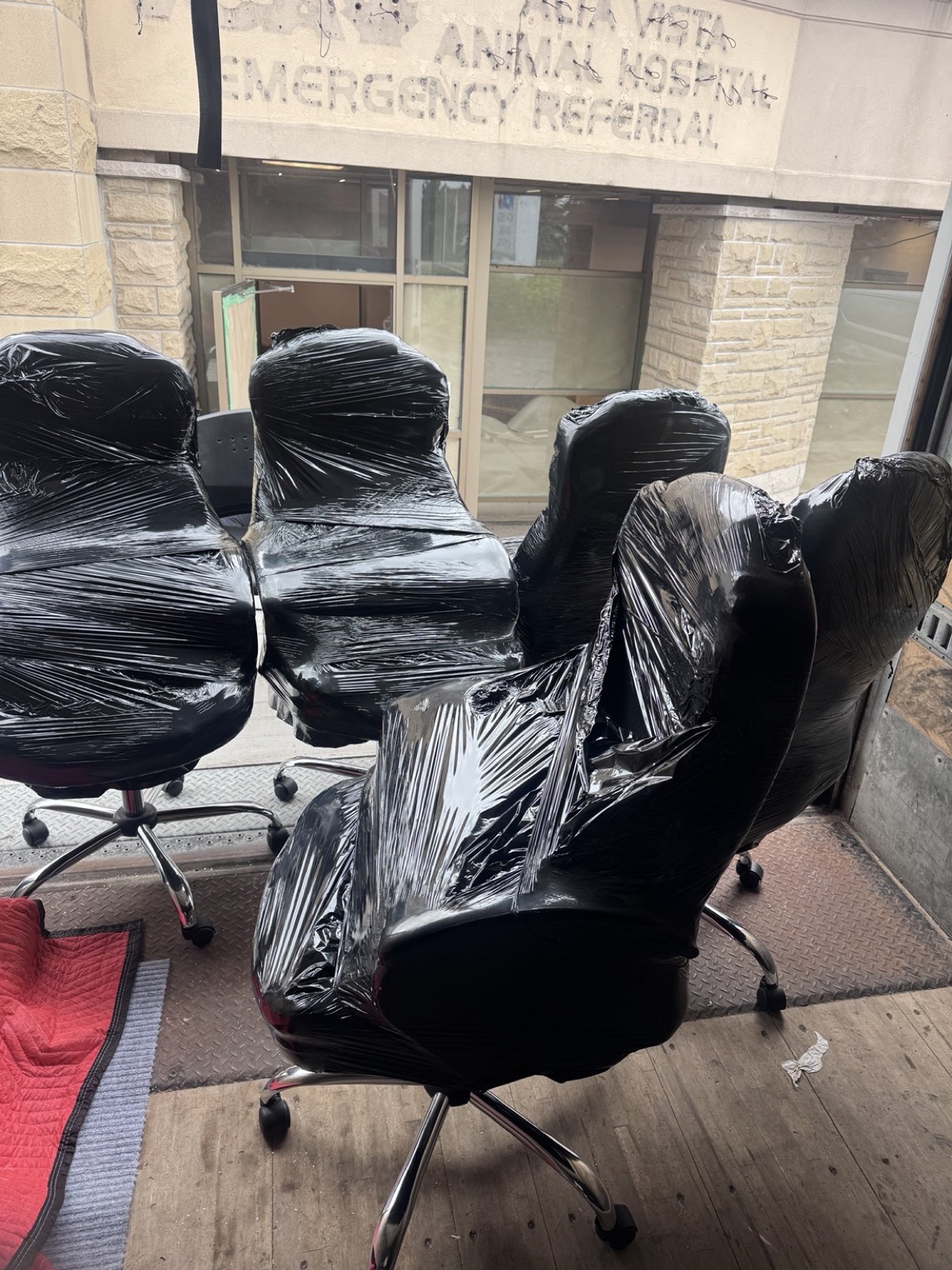 Shrink-wrapped office chairs on the truck liftgate during an Ottawa clinic office move